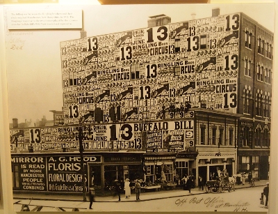 [One side of a four story building is completely covered with Ringling posters except for the windows and the two Buffalo Bill posters.]